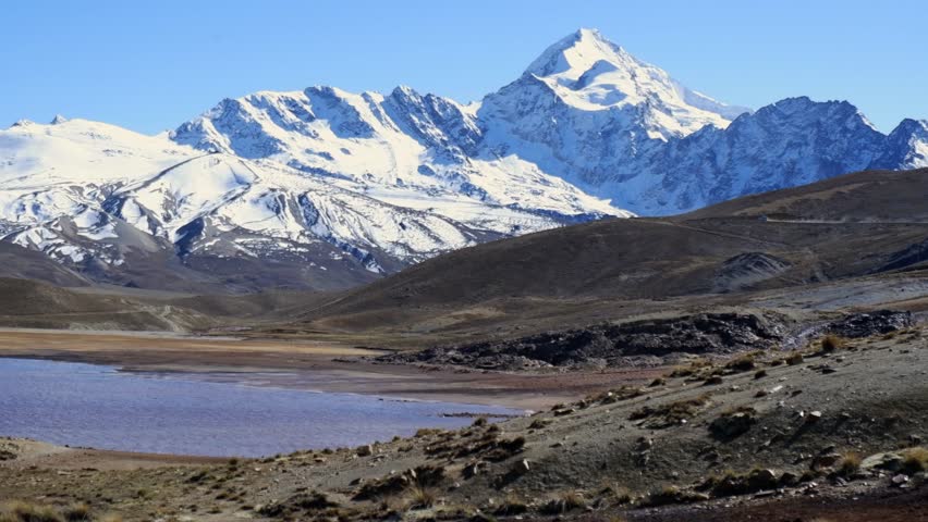 Pan across high altiplano landscape in snow capped Bolivian Andes mtns, Huayna Potosi