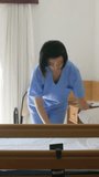 Asian nurse making a hospital bed. Vertical Video