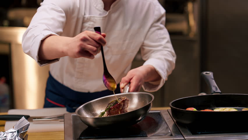 close-up of seared beef steak with rosemary topped with melted butter in a frying pan