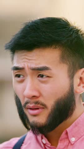 Chinese man in casual clothes snotting with a tissue in the street