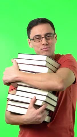 Merry man hugging pile of books and smiling against chromakey