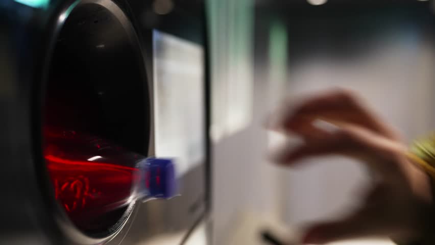 Woman puts bottle in automatic bottle recycling machine. Reverse vending recycling machine.