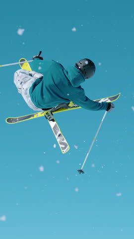 SLOW MOTION, CLOSE UP Action shot of an expert freestyle skier taking off a kicker and doing a 360 grab while exploring , Slovenia. Skier riding in the mountains of Slovenia does a cool trick.