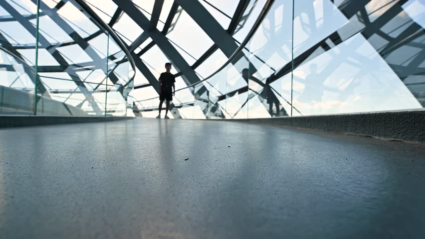 Berlin, Germany, August 15, 2023. Fascinating conceptual footage inside the glass and metal dome located on the roof of the Reichstag building. The silhouette of a young man advances towards us.