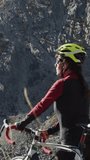 Vertical video. Portrait of cyclist woman on top of the mountain. 
