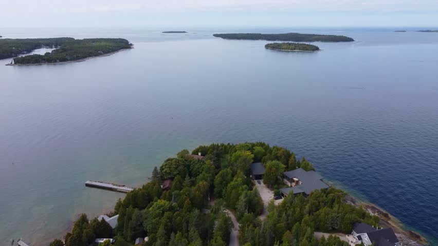 Waterfront Villas On Island With Green Foliage. Georgian Bay In Ontario, Canada. aerial tilt-down