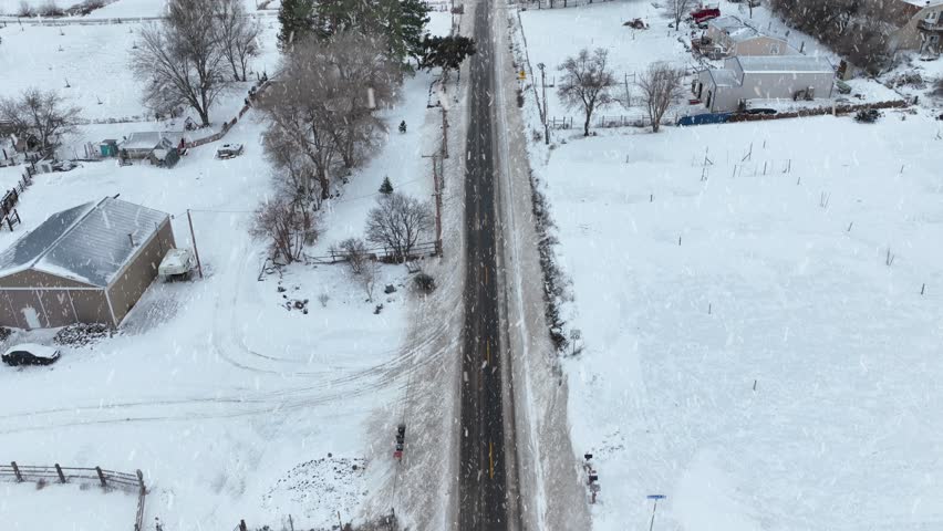 Drone shot of snow falling on a rural road in Eastern Washington. Royalty-Free Stock Footage #3448283107