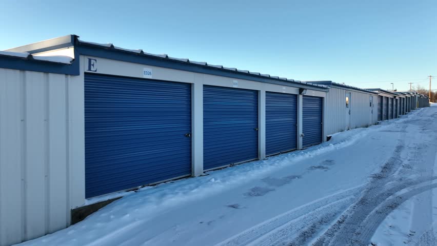 Blue Self Storage Unit Buildings or Warehouse Temporary Storage in winter. American suburb garage. Aerial passing by. Royalty-Free Stock Footage #3448292903