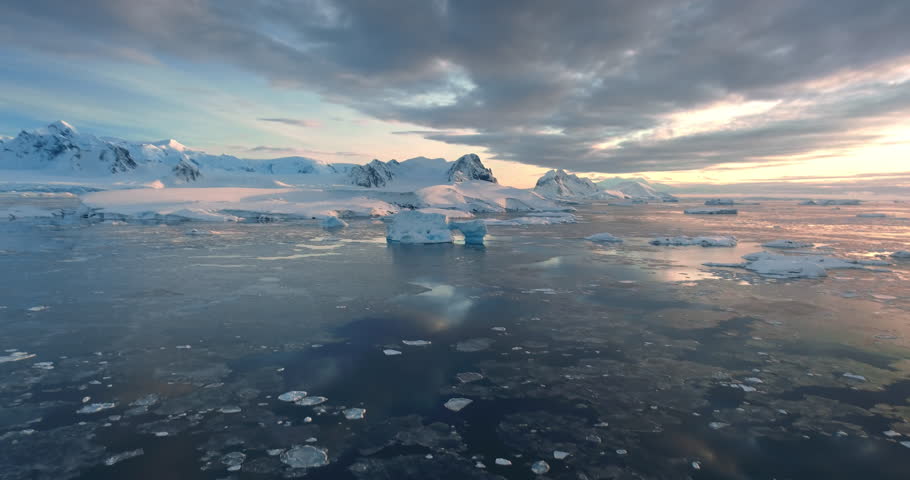 Breathtaking winter Arctic aerial sunset landscape. Frozen beauty Antarctica nature. Colorful clouds sky reflected in Polar frozen ocean water. Snow covered mountain, glacier, iceberg. Travel, explore Royalty-Free Stock Footage #3448293801