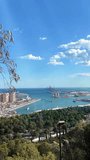 Vertical Video of coastline of Malaga city, view from above with clear blue sky.