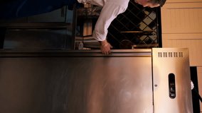 vertical video professional kitchen chef looks into fridge and chooses ingredients for cooking food concept