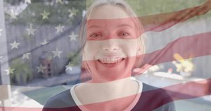 Animation of smiling caucasian woman over flag of usa. American patriotism and tradition concept digitally generated video.