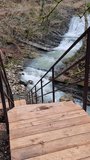 Beautiful autumn hiking trail with staircase near waterfall in forest
