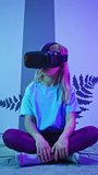 Female child using new technologies, having fun wearing virtual reality goggles in the VR room of natural history museum, front view. vertical video