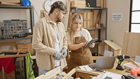 Man and woman collaborate in a woodworking workshop, surrounded by tools and wooden frames. - Powered by Shutterstock - Get 15% off with code: PIKWIZARD15