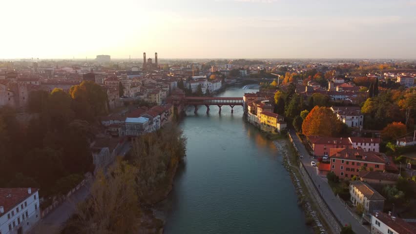 AERIAL: Bassano del Grappa historical bridge panoramic view in a sunny day with flare. Royalty-Free Stock Footage #3448648111
