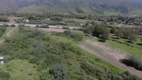 Drone Footage: A Green Valley with Streets, Houses, and Man-Made Fields
