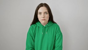 Shocked young caucasian female in sweatshirt standing, with an expression of fear and astonishment etched on her face, isolated on a white background.