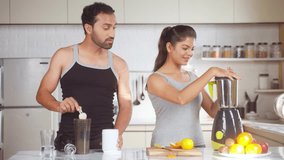 Healthy Indian couple preparing fruit juice and protein shakes after working out at kitchen - concept of active lifestyle, healthy fitness routine - Powered by Shutterstock - Get 15% off with code: PIKWIZARD15