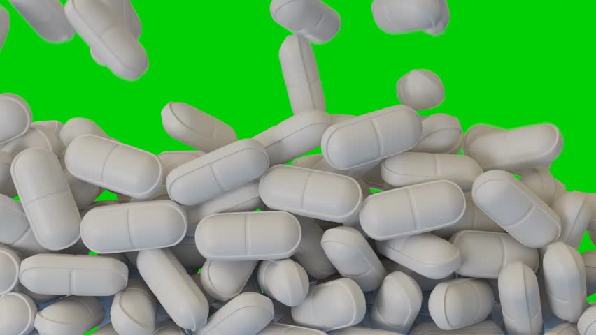 white pills fall and cover the green screen