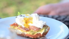 slow motion video of a poached egg brunch with seeds on salmon