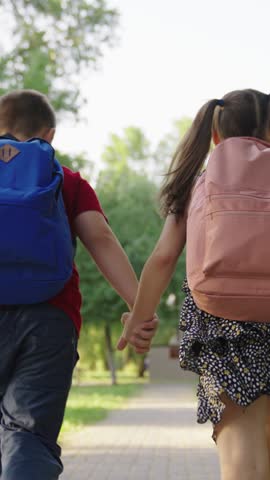 boy girl holding hands running through park school, child with school backpacks running along sidewalk school lesson, cheerful classmates running hand hand with bags, teamwork group children, boy girl