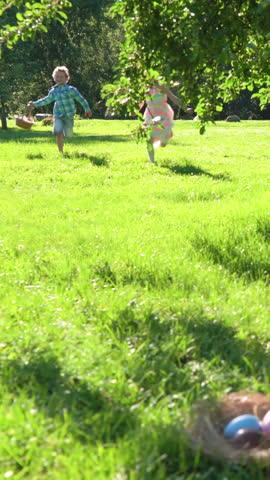 Two children boy and girl having easter egg hunt in garden backyard Royalty-Free Stock Footage #3448932897