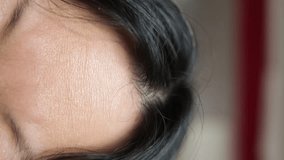 Close-up portrait of Asian woman displeased with wrinkles on her forehead. Horizontal wrinkles on the female forehead, vertical video. - Powered by Shutterstock - Get 15% off with code: PIKWIZARD15
