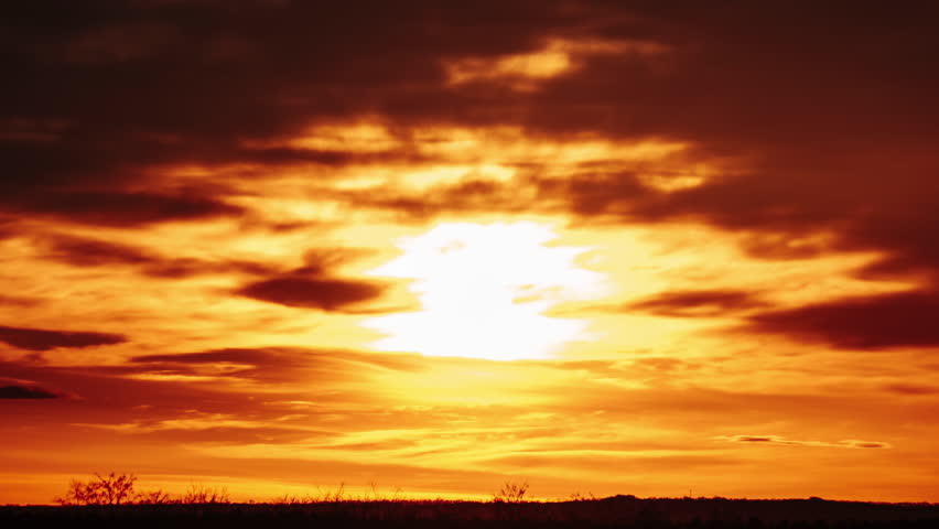 Timelapse sunset above the horizon in orange sky with dramatic clouds. 4K. Bright sun setting down above the horizon. Colorful dark sunset epic clouds. Vibrant color. Time-lapse. Sundown