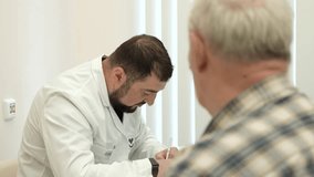 Elderly man at doctor's appointment. Clip. Grandpa is at doctor's appointment. Therapist prescribes treatment for elderly man