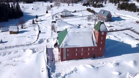 Top view of small village with cottages in winter. Clip. Small village in forested area on sunny winter day. Remote village with large brick house