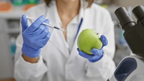 Scientist in lab coat injecting green apple with syringe, concept of genetic modification - Powered by Shutterstock - Get 15% off with code: PIKWIZARD15