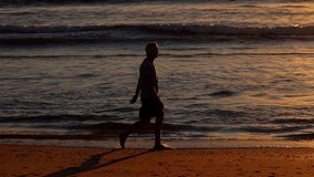 64 year old man getting his exercise at the beach at sunset. Slow Motion. - Powered by Shutterstock - Get 15% off with code: PIKWIZARD15