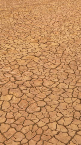 AERIAL: Aerial view of cracked land caused by long draught. Brown desiccated soil with ground cracks and no vegetation. Dry landscape with crack pattern caused by lack of water. Royalty-Free Stock Footage #3449015717