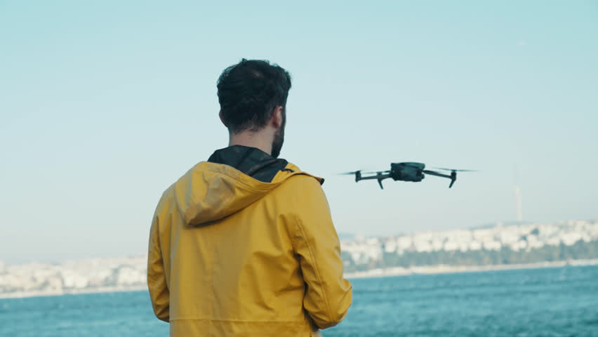 Young man piloting a drone flying 