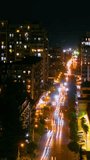Timelapse, vertical video: city highway traffic - street with apartment, residential buildings, fast moving cars and light trails in Batumi, Georgia at night. Time lapse and transportation concept