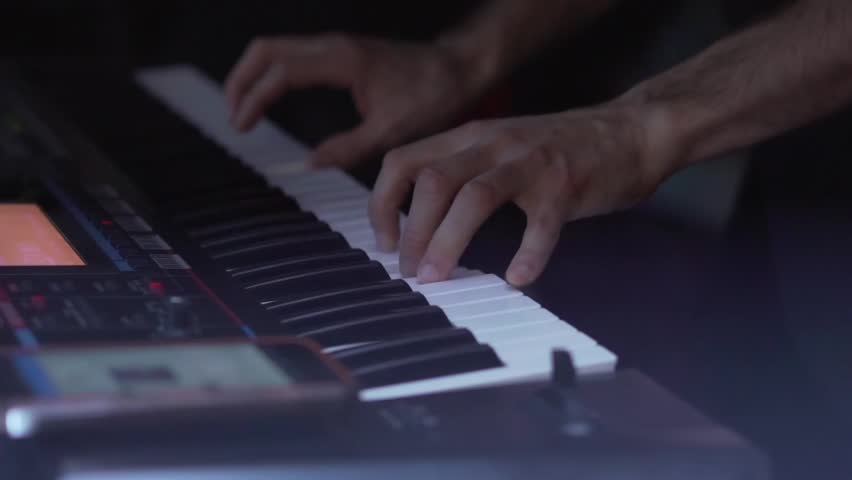 A musician plays a synthesizer in a musical group. Pianist Musician Performs Live Keyboard Game In A Band - Powered by Shutterstock - Get 15% off with code: PIKWIZARD15