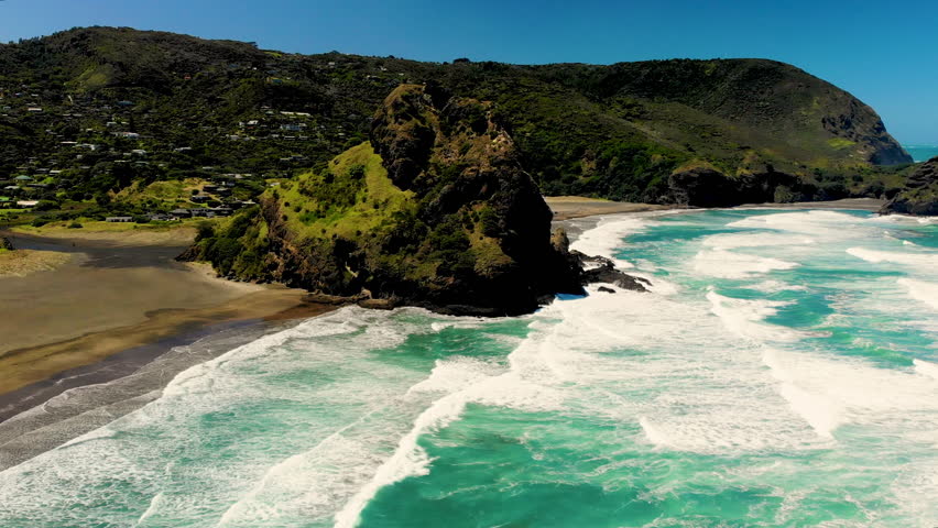 Black sand Piha beach, West of Auckland, New Zealand. Aerial orbit reveal seascape