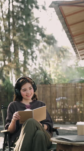 Attractive young lady in casual clothing is reading book sitting in cafe relaxing. Millennials, modern lifestyle concept