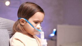 close-up of girl wearing nebulizer mask, inhaler. Girl inhales medication vapor