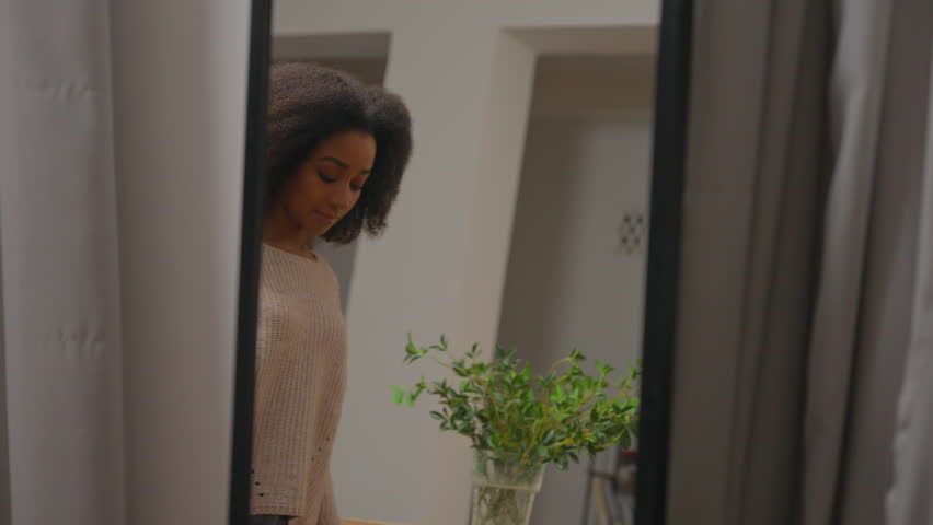 Unhappy African American woman looking in mirror reflection at home wear jumper casual style unhappy bad choice clothes quality apparel outfit dissatisfied customer girl in clothing shop dressing room Royalty-Free Stock Footage #3449163073