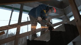 Man works as grinder at construction site. Clip. Man cuts metal pipe with sparks with circular saw. Sparks from cutting with circular saw on metal