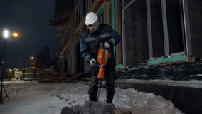 Man drills cement blocks. Clip. Worker splits cement blocks at construction site with hammer drill. Breaking apart cement blocks with drill