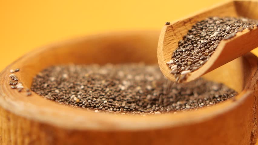  chia seed pouring from a wooden spoon 