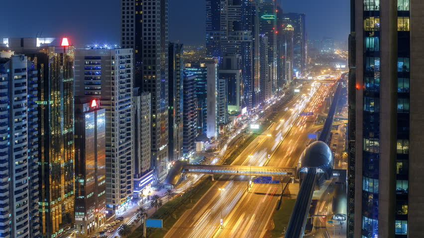 Spectacular nighttime skyline of Dubai, UAE. Top view of business bay skyscrapers, highway with light trails and metro station. 4K time lapse.  | Shutterstock HD Video #34492177