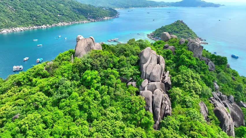Dive into paradise on an island linked by enchanting sandbars, offering pristine snorkeling and diving in translucent waters. Drone aerial view. Ko Tao, Surat Thani Province, Southern Thailand. 4K.  
