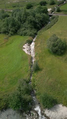 beautiful scenic ladscape in alpine mountain snowy and greenery meadow with a little river
