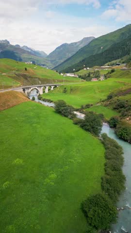 beautiful scenic ladscape in alpine mountain snowy and greenery meadow with a little river