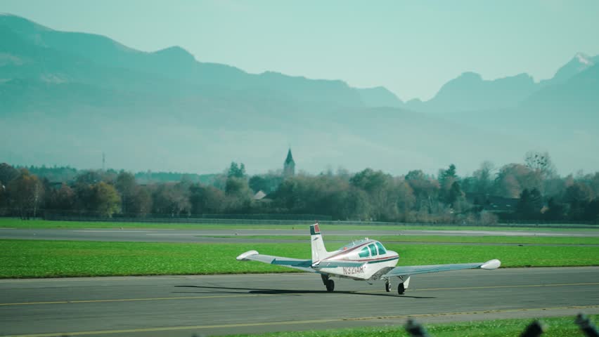 Small single engine aircraft taxiing at scenic Austrian airport Salzburg located within the mountains