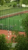 Kingdom of youthful energy unfolds with kids playing soccer in a blurred stadium vertical video